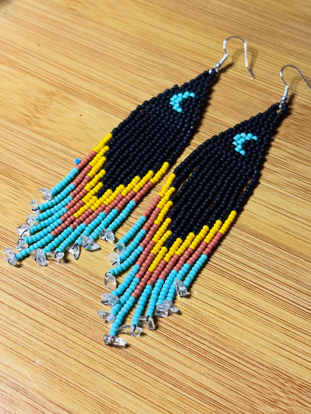 Red Road Moonrise beaded fringe earrings angled view on wood surface